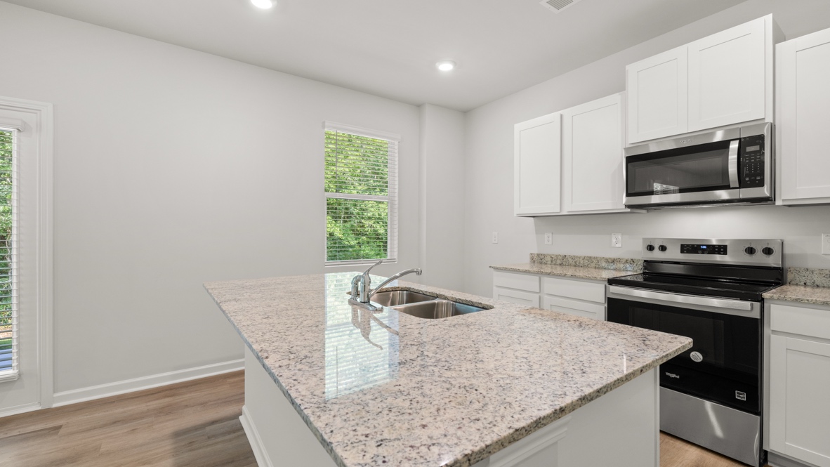 Interior kitchen with center island and white cabinets