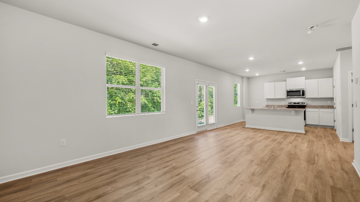 Interior living area with large windows and open to kitchen