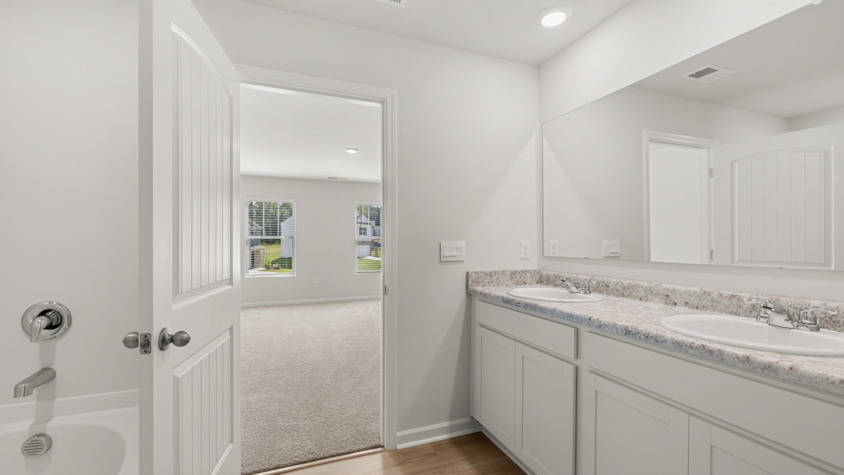 Interior primary bathroom with double sink and bath tub