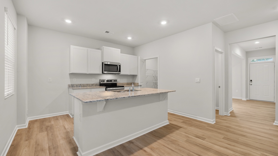 Interior kitchen with center island and white cabinets
