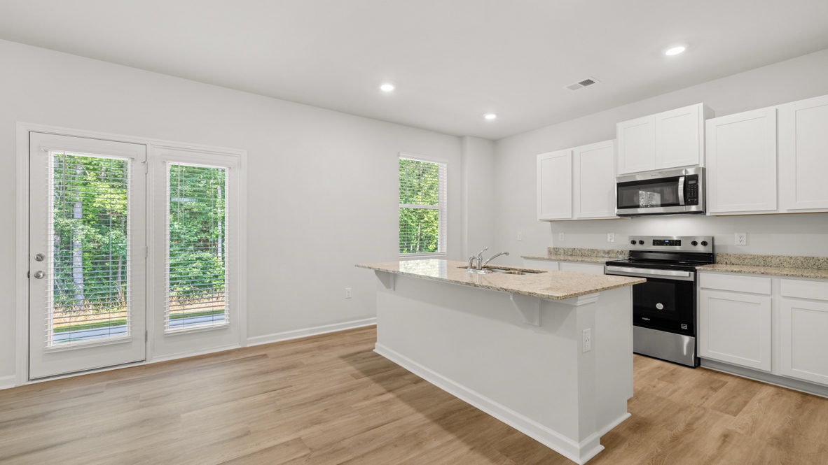 Interior kitchen with center island and white cabinets