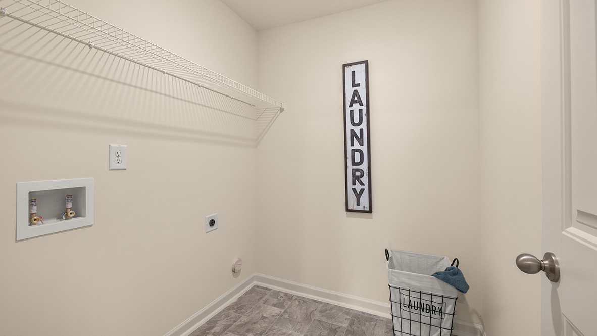Laundry room in the Penwell Plan is craftily designed with upper cabinetry and a Brand New Stainless Steel washer and dryer