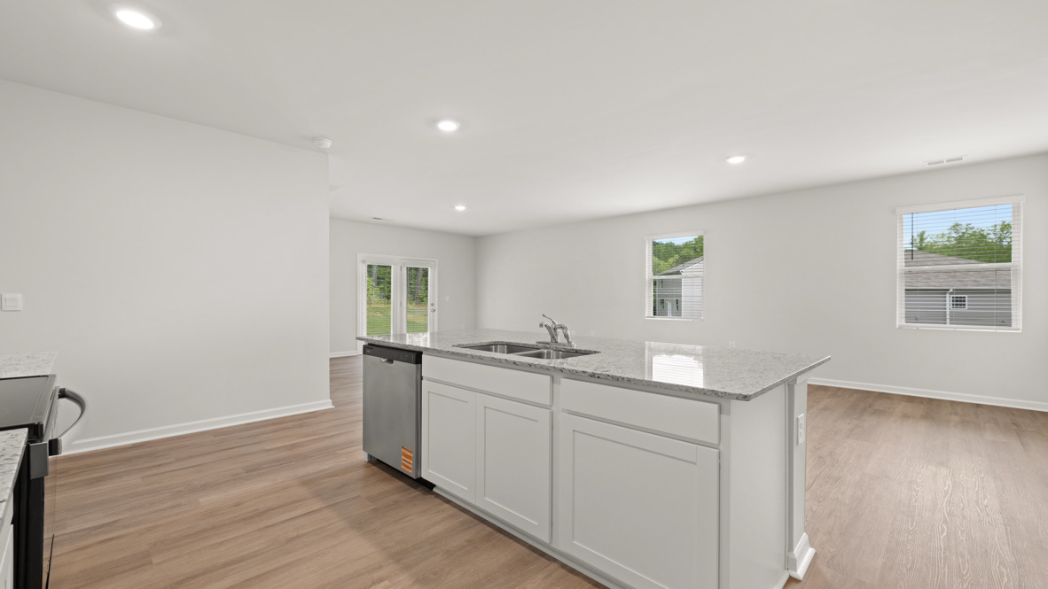 Kitchen view of the dining room and stainless steel appliances.