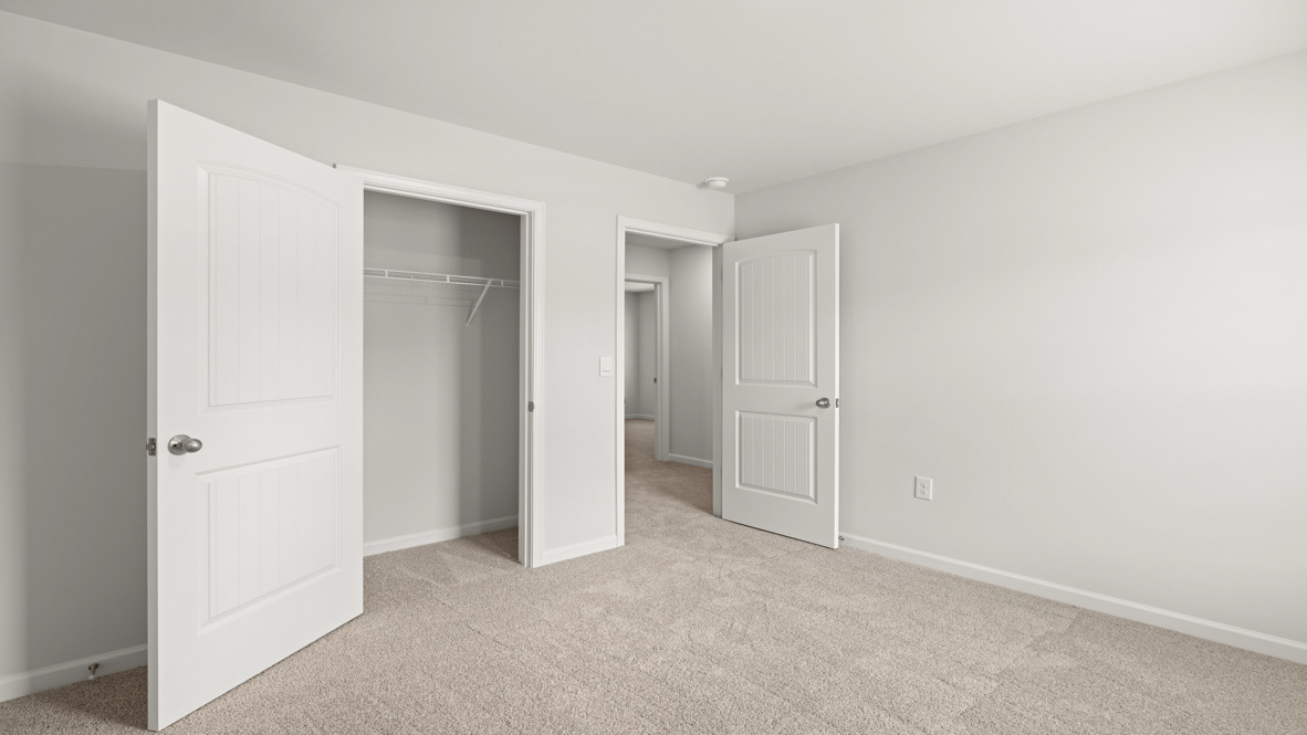 Carpeted bedroom with a closet.