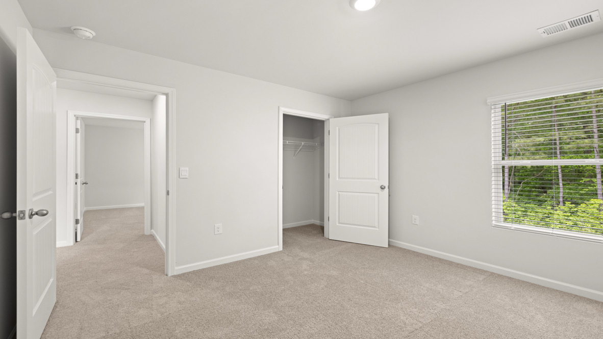 Carpeted bedroom with a closet.