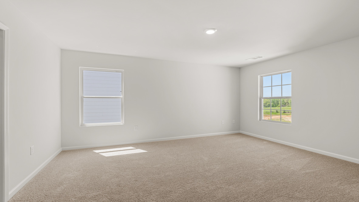 Interior primary bedroom with large windows