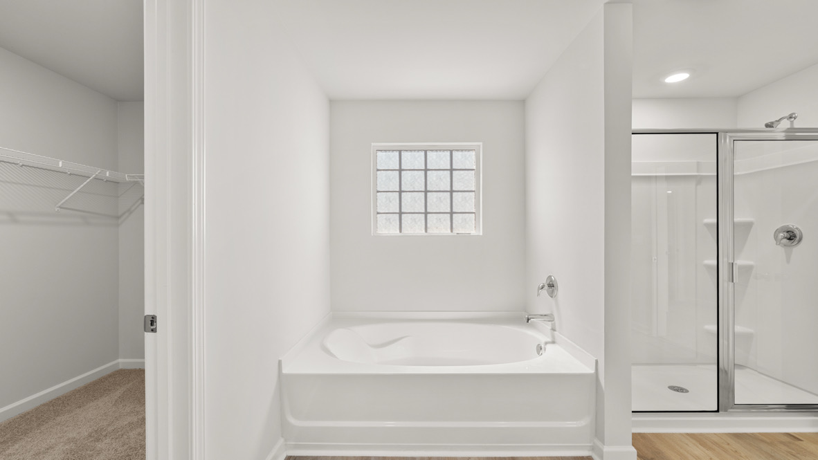 Interior primary bathroom with bath tub and shower
