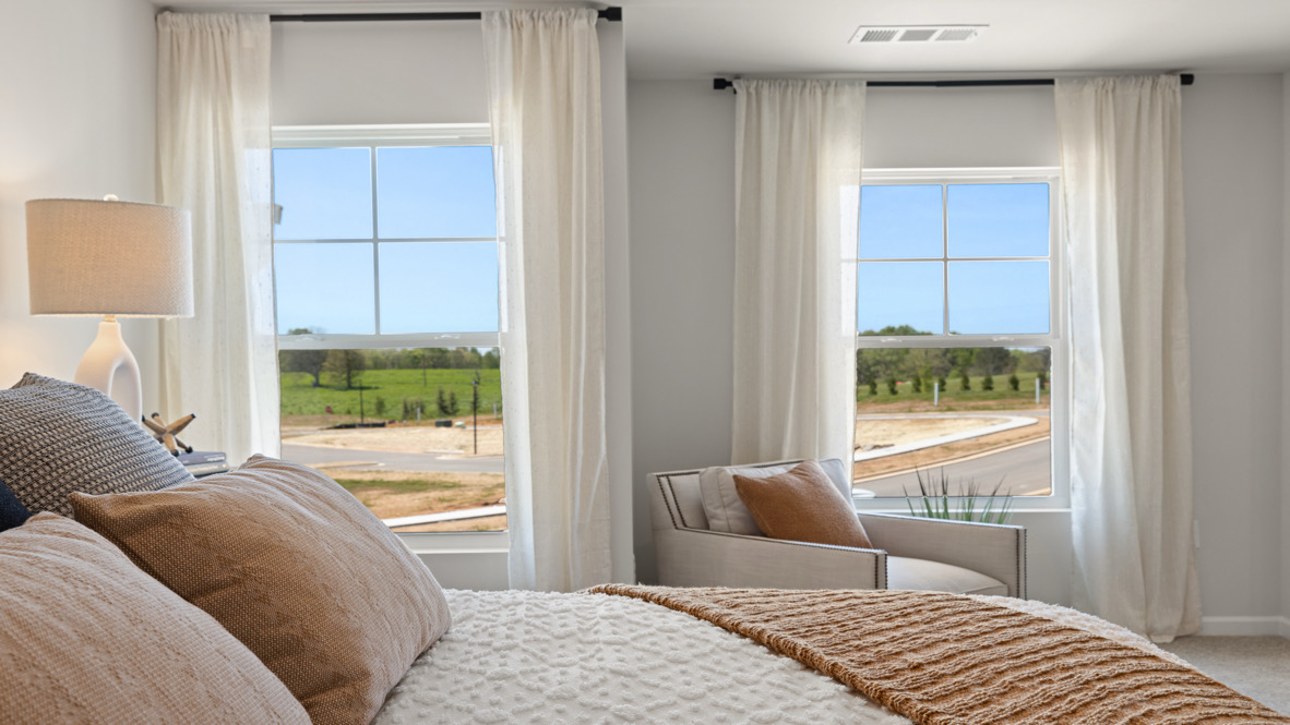 Interior primary bedroom with large windows