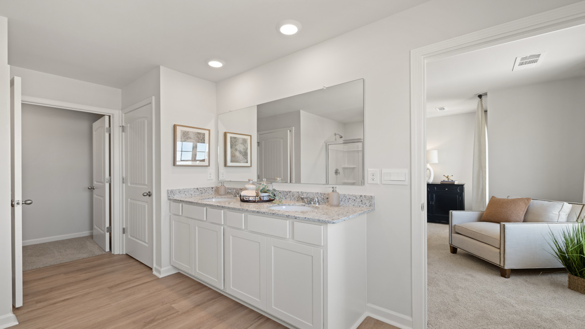 Interior primary bathroom with double sink and walk-in closet