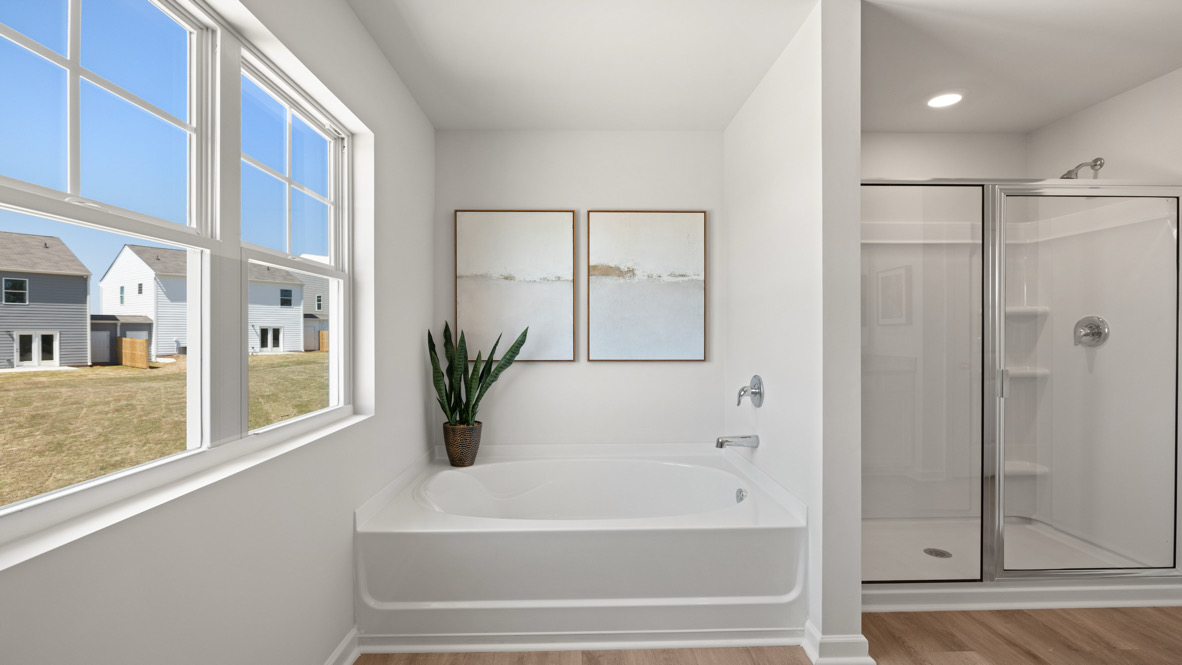 Interior primary bathroom with bath tub and shower