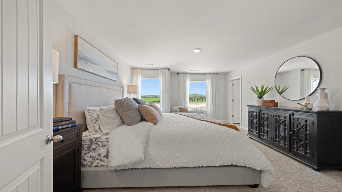 Interior primary bedroom with large windows