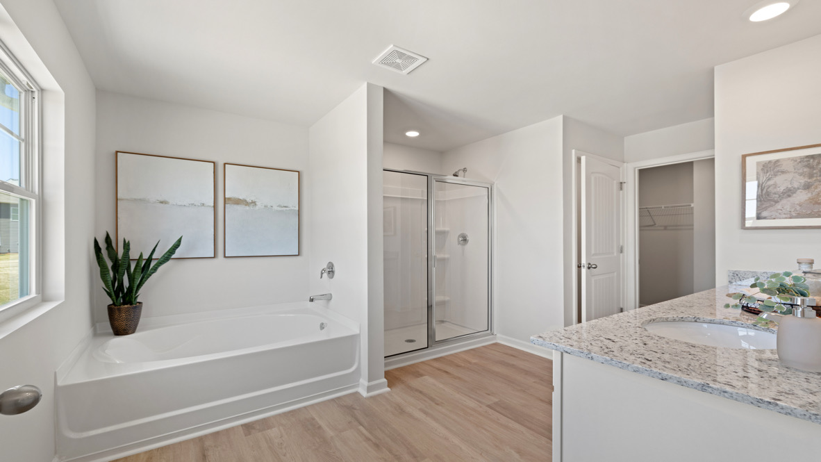 Interior primary bathroom with bath tub, shower and double sink