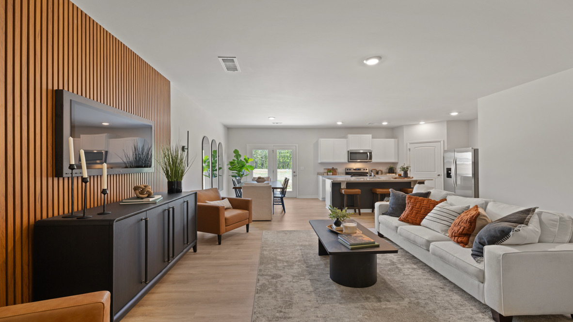 Modern living room in New Home For Sale by D.R. Horton offers backyard visibility and kitchen access