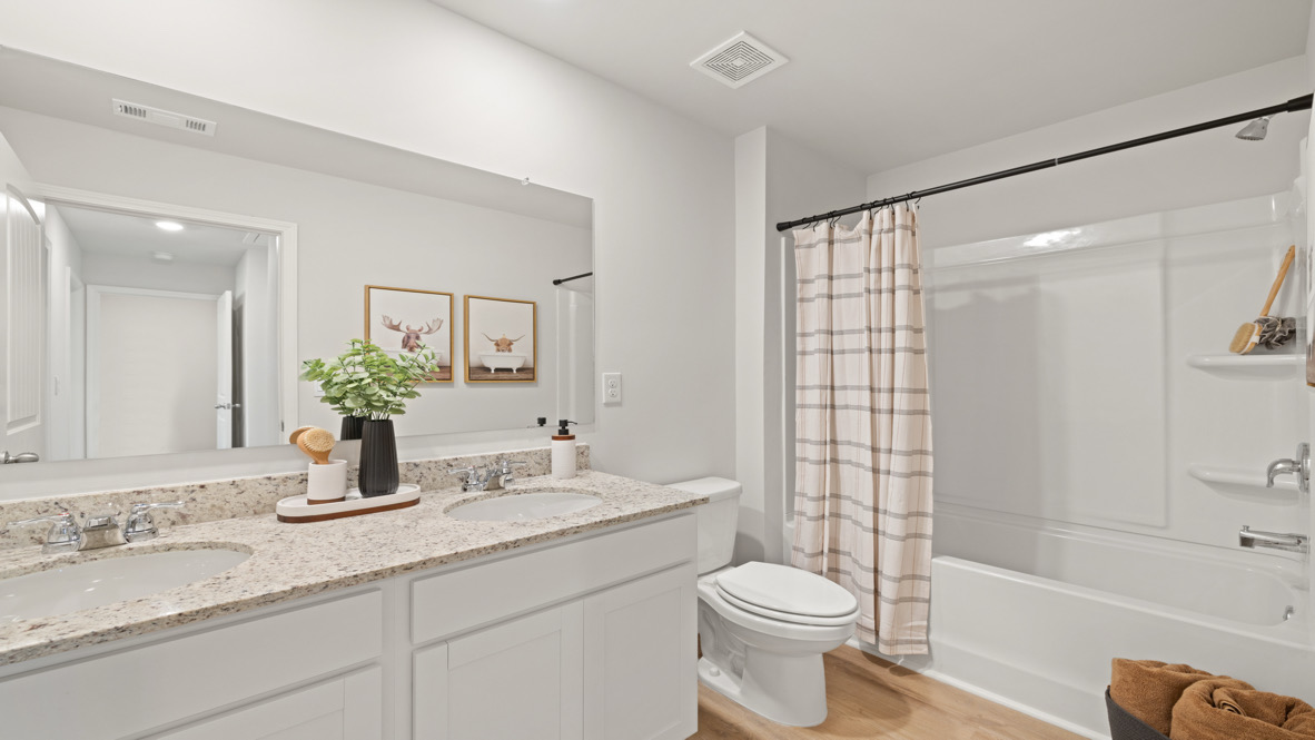 secondary bathroom in Rolling Meadows includes full-length vanity, hard surface countertops, and storage cabinetry crafted by D.R. Horton