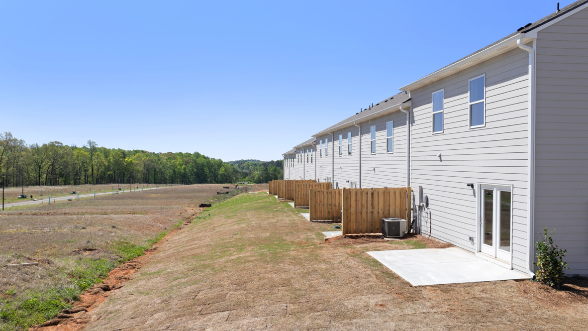 Rear elevation view showing patio access and lawn depth