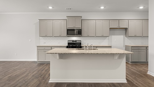 halton kitchen with grey cabinets and large granite island at palisades in dallas georgia