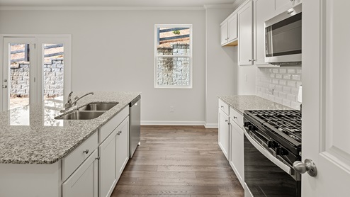 sample Penwell kitchen with white cabinets and granite countertops at palisades in dallas georgia