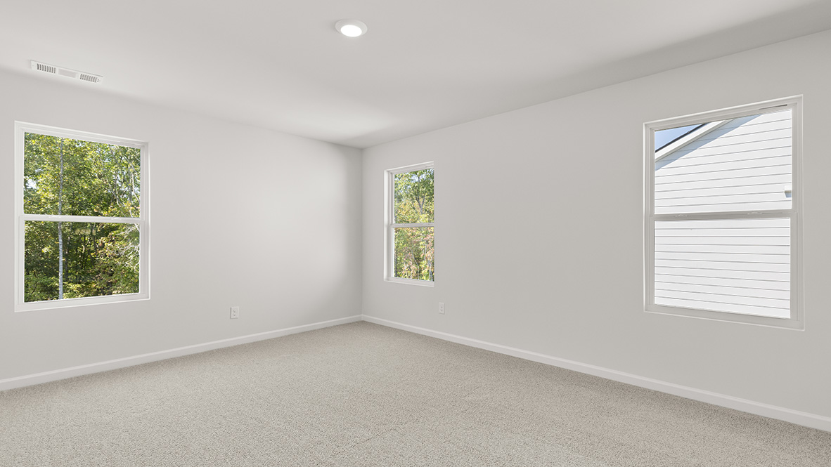 Interior primary bedroom with large windows