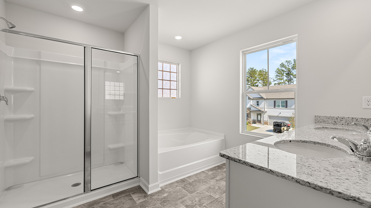 Interior primary bathroom with shower, bath tub and double sink