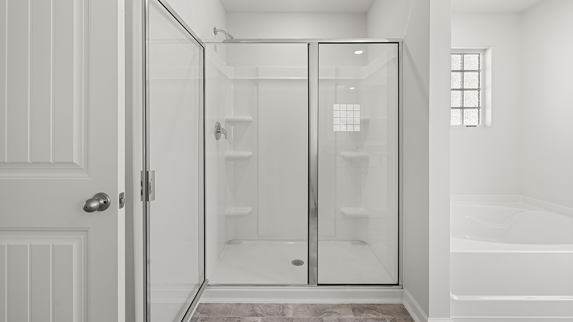 Interior primary bathroom with shower and bath tub