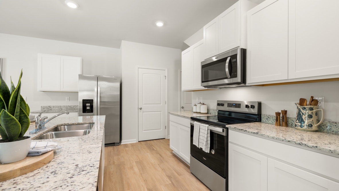 Interior kitchen with center island and white cabinets