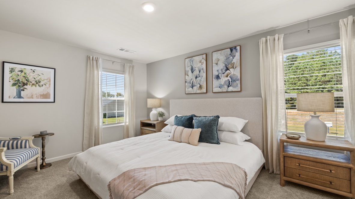 Interior primary bedroom with large windows