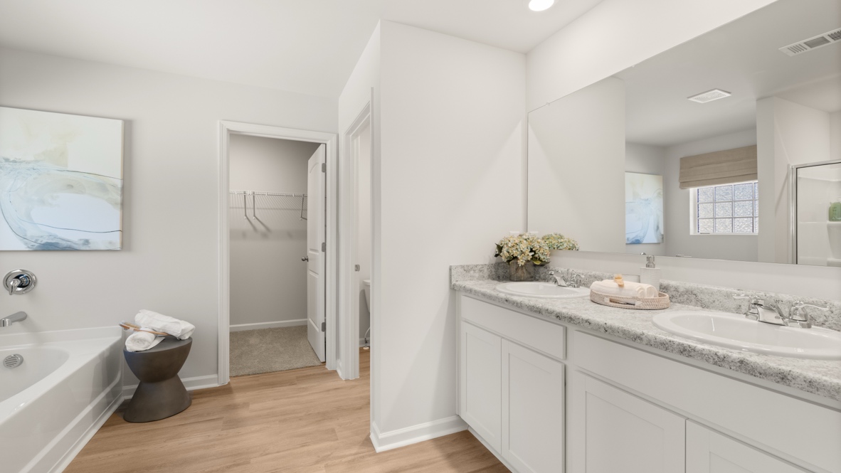 Interior primary bathroom with double sink and bath tub
