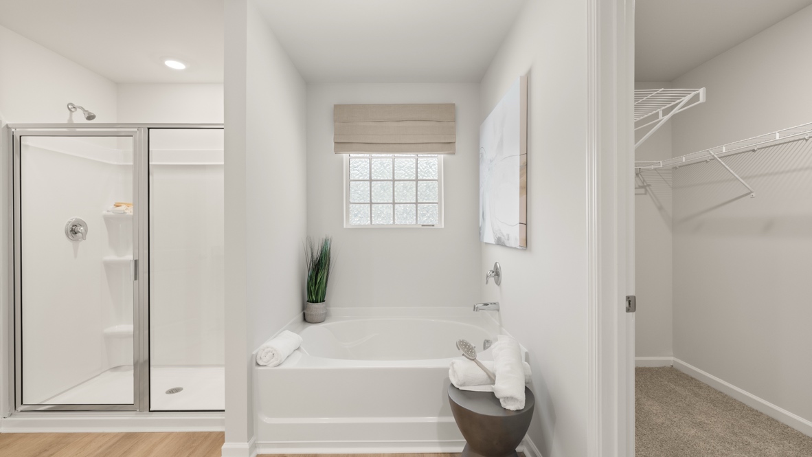 Interior primary bathroom with shower and bath tub