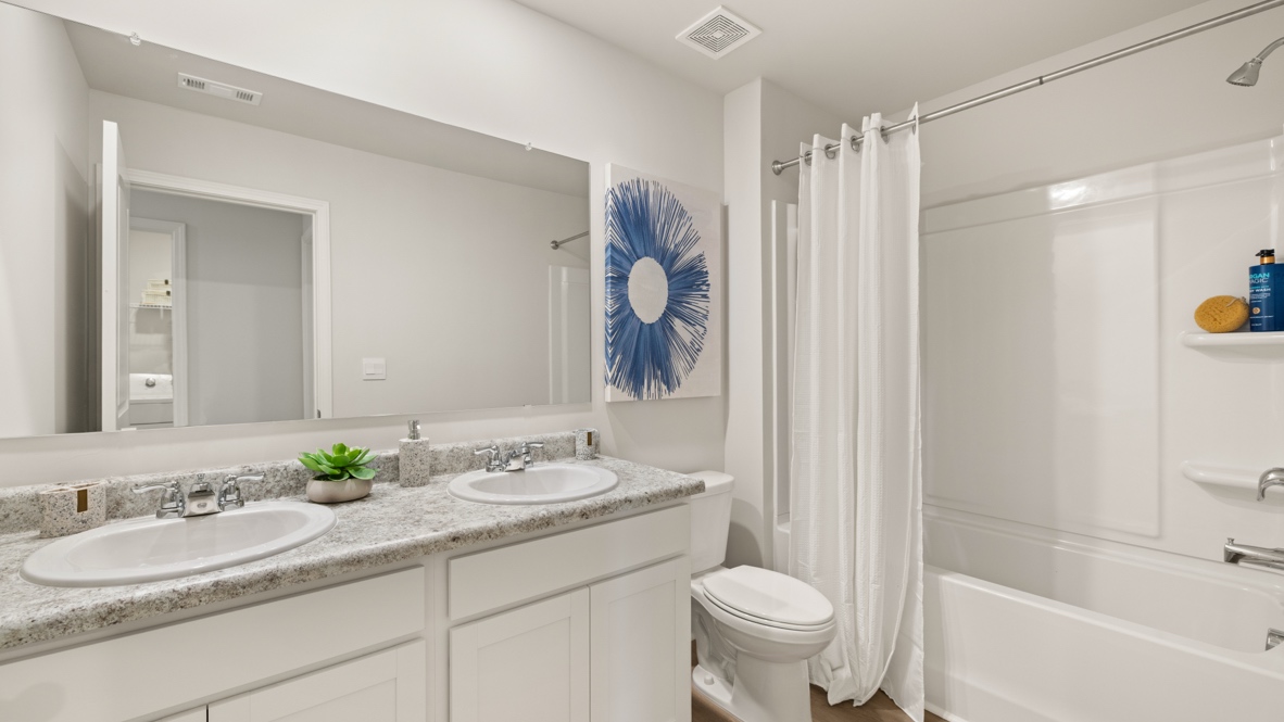 Interior bathroom with double sink and full-sized shower