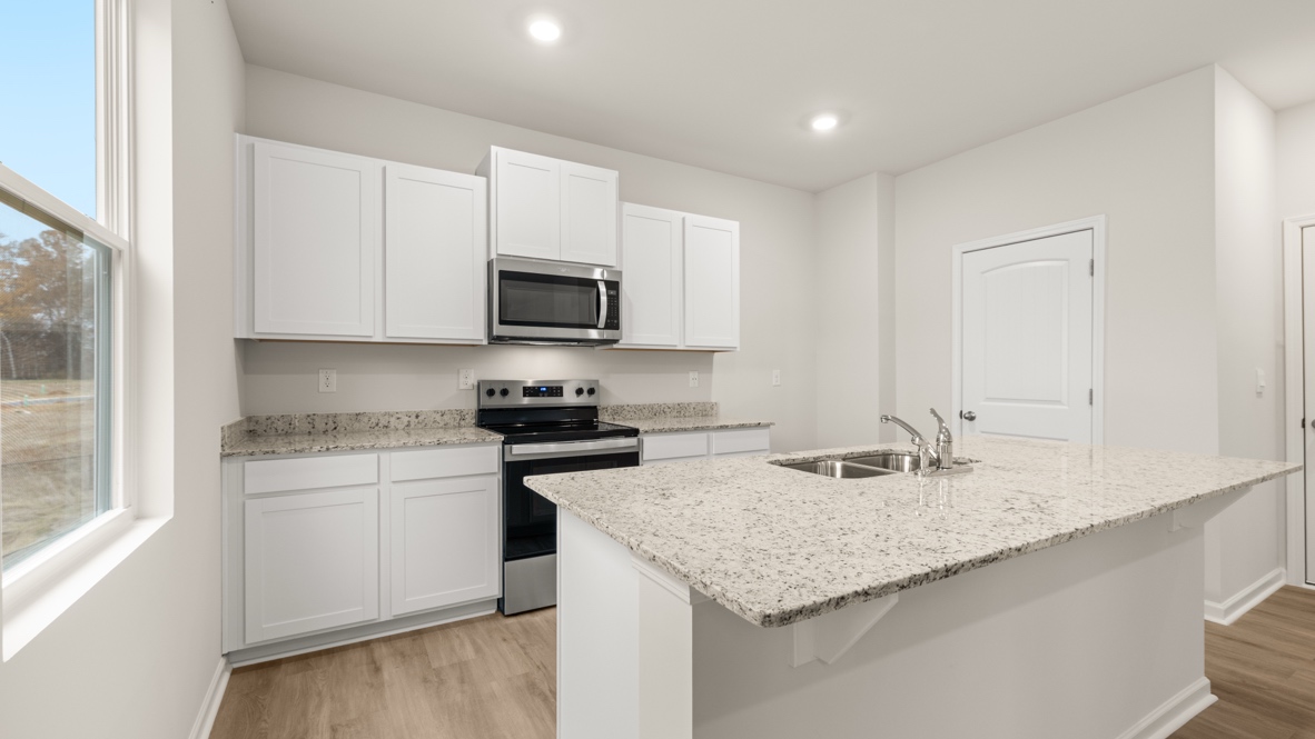 Interior kitchen with center island and white cabinets