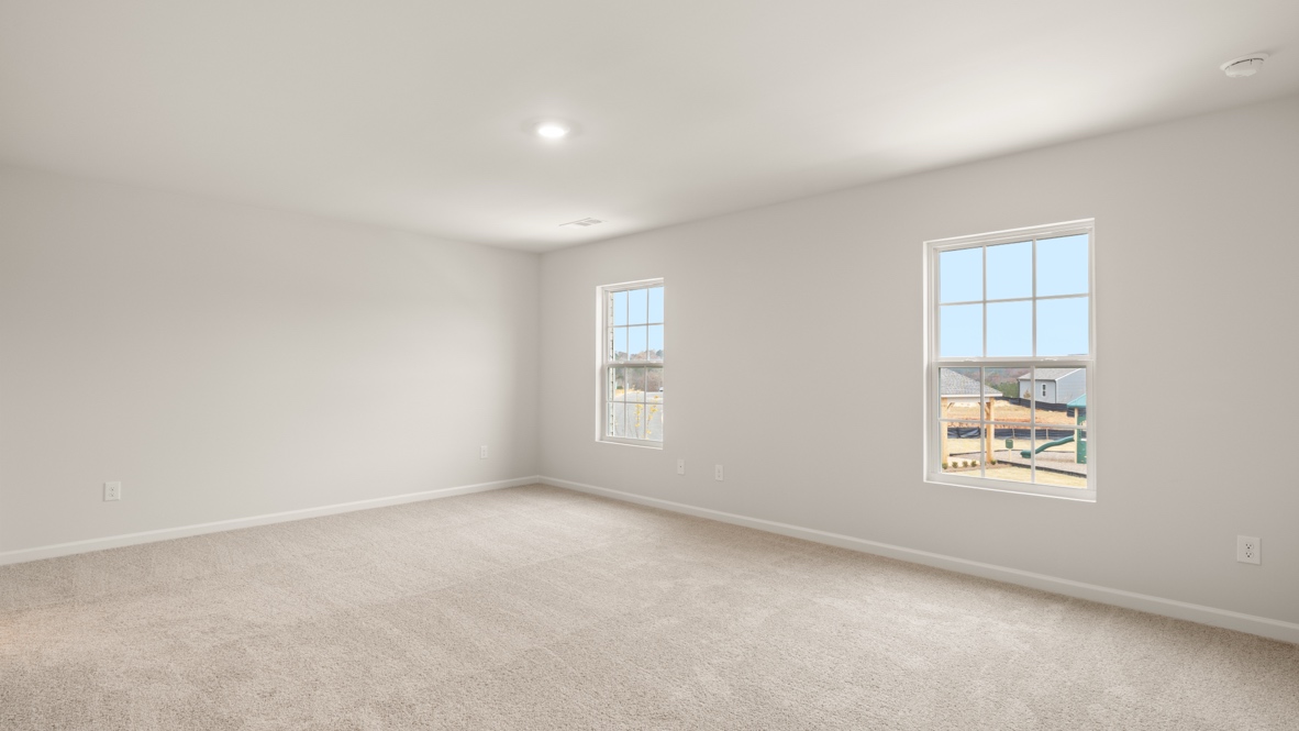 Interior primary bedroom with large windows