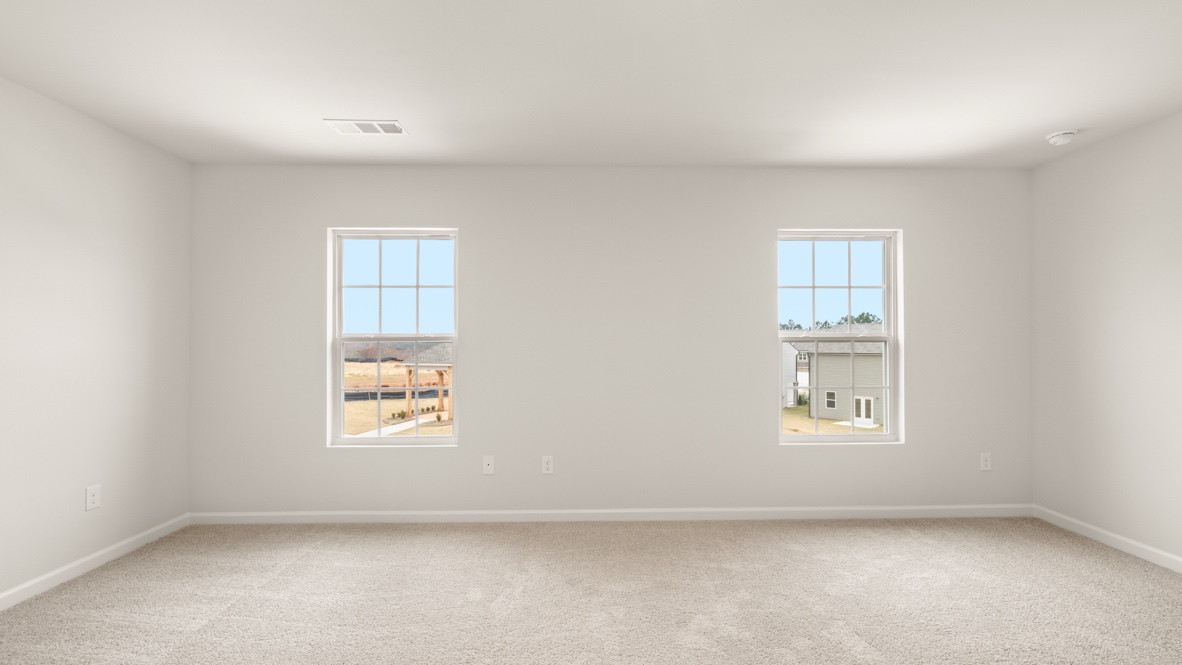 Interior primary bedroom with large windows