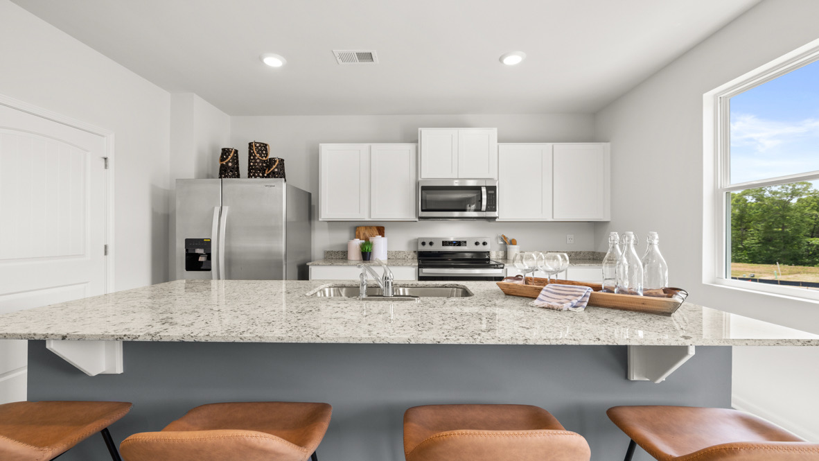 Interior kitchen with center island and white cabinets