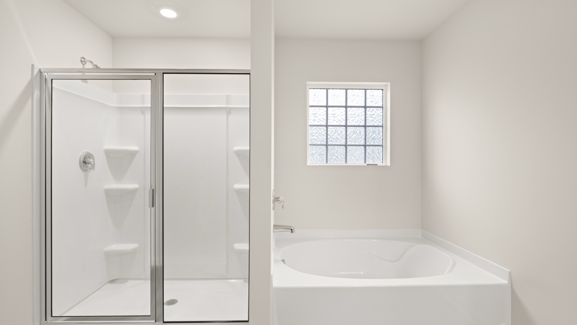Interior primary bathroom with shower and bath tub