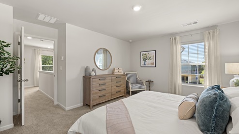 Interior primary bedroom with large windows