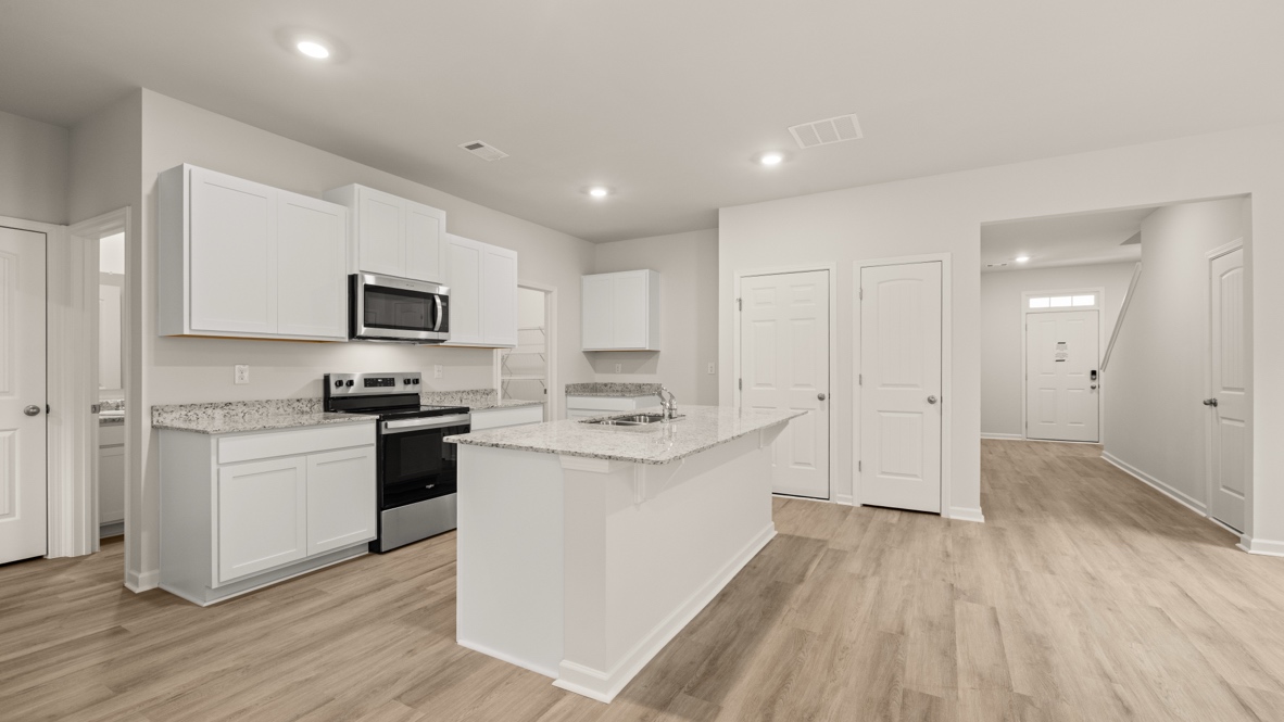Interior kitchen with center island and white cabinets