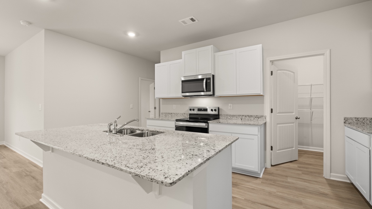 Interior kitchen with center island and white cabinets