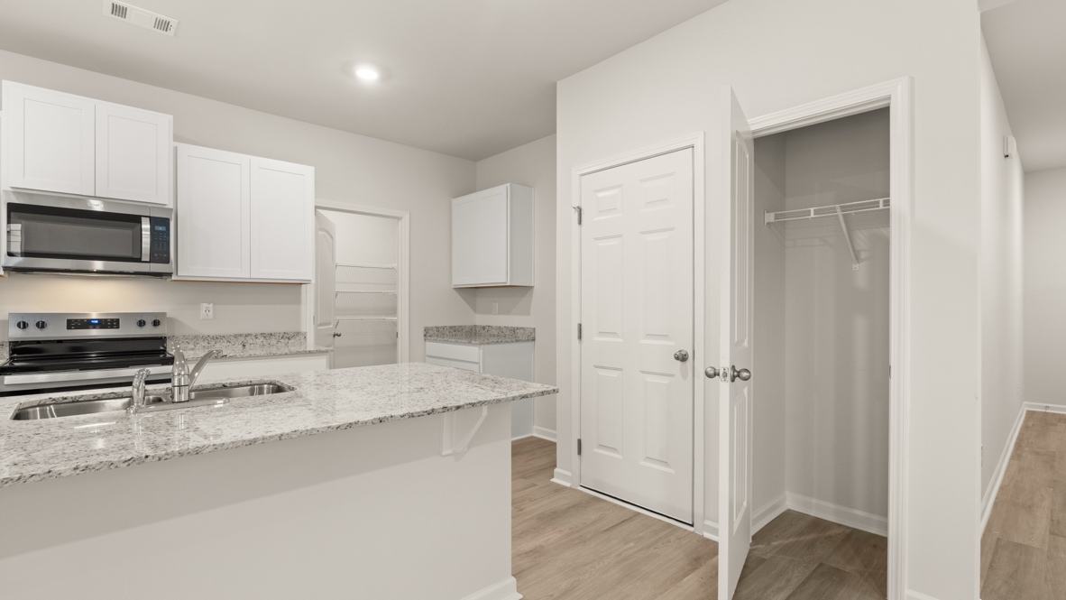 Interior kitchen with center island and white cabinets