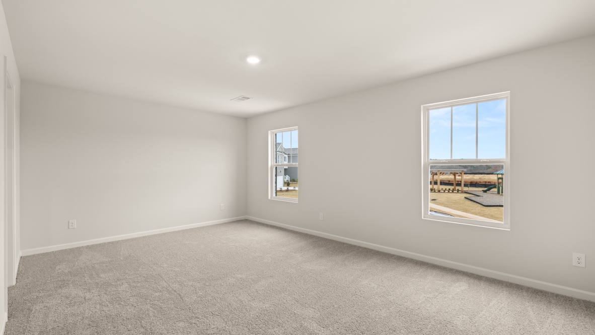 Interior primary bedroom with large windows