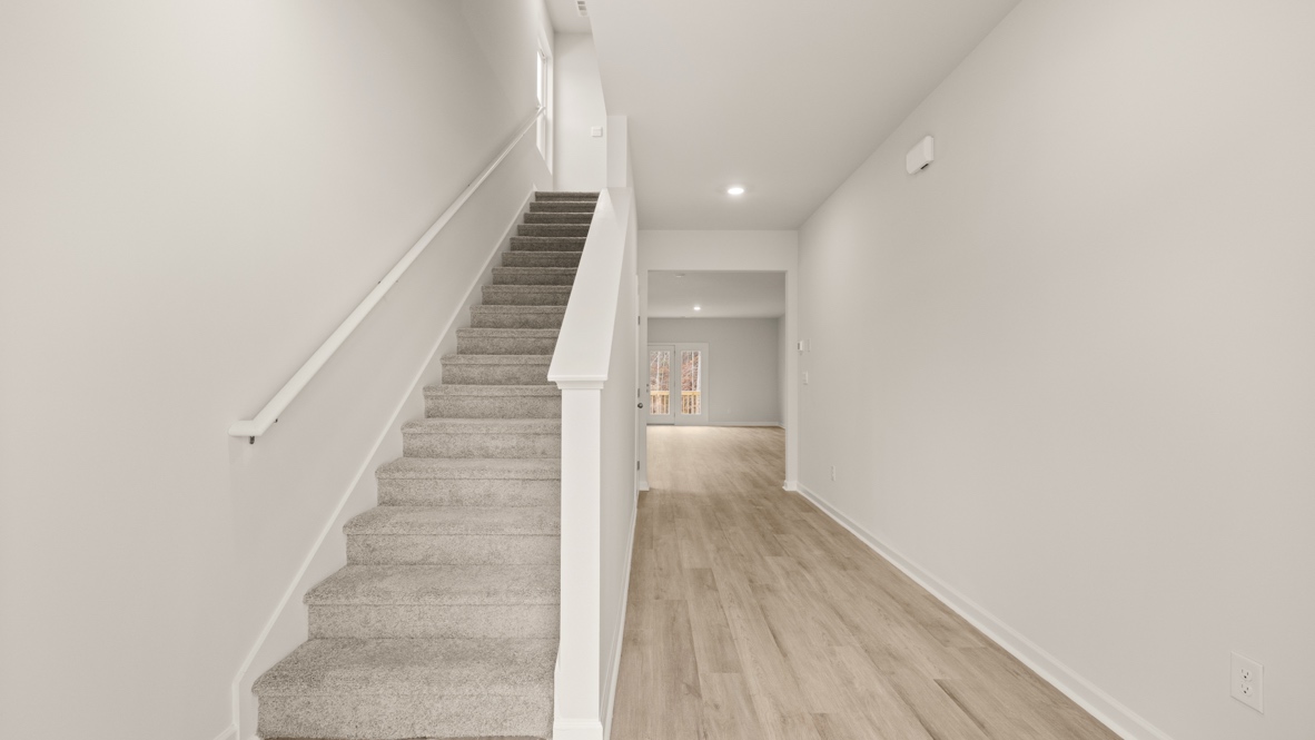 Interior entry-way open staircase and leadign to living area