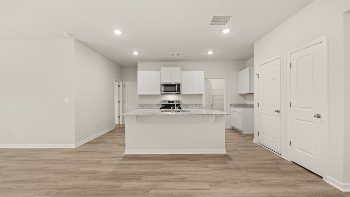 Interior kitchen with center island and white cabinets