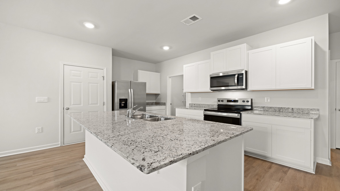 Modern kitchen with granite countertops, stainless steel appliances, white cabinets, and light wood flooring. Bright, clean, and minimalistic design.