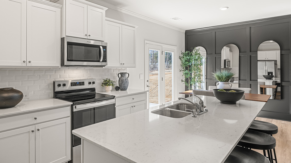 Interior kitchen with center island and white cabinets