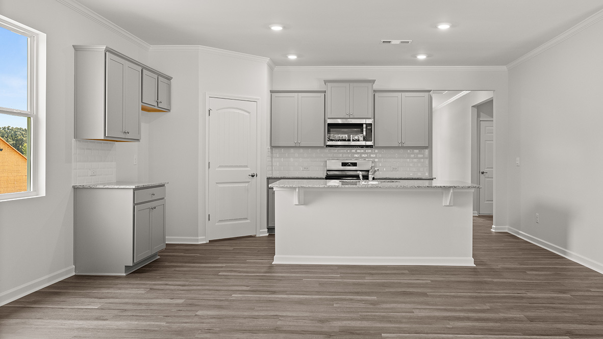 kitchen with light grey cabinetry, large island and stainless steel appliances