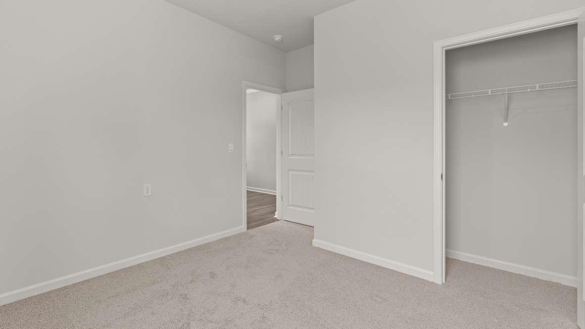 bedroom with beige carpet, white walls and a window