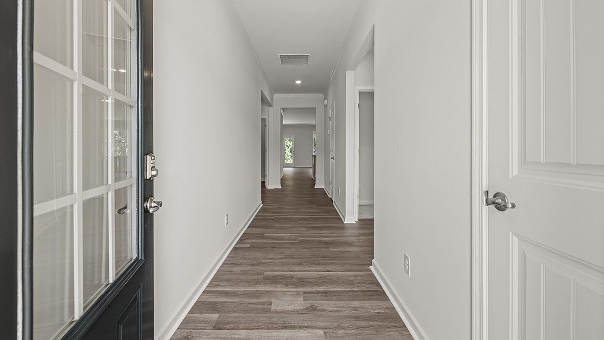 front entry way of home featuring brown flooring and white walls