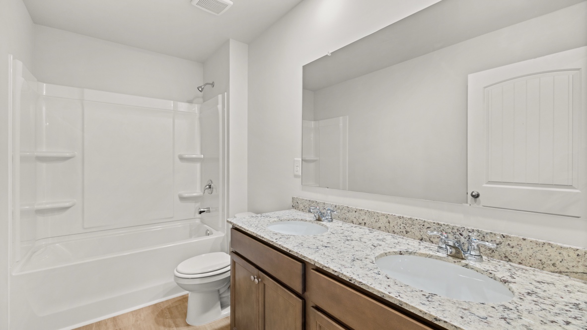 Interior bathroom with double sink and full-sized shower