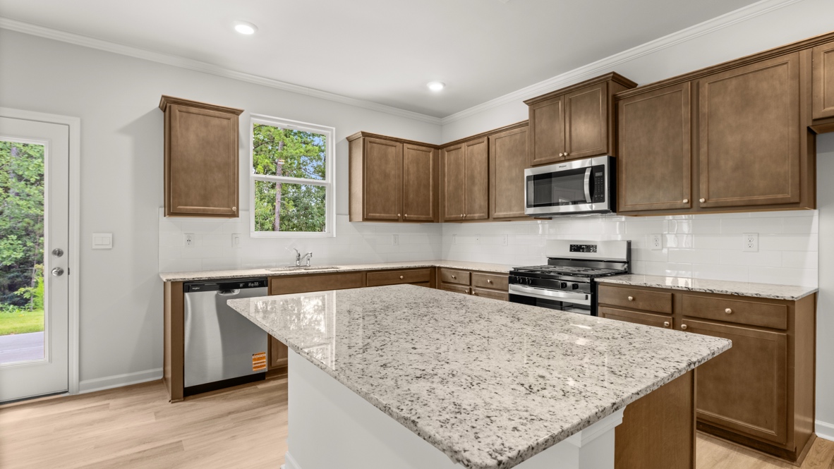 kitchen with brown cabinetry, large island and stainless steel appliances