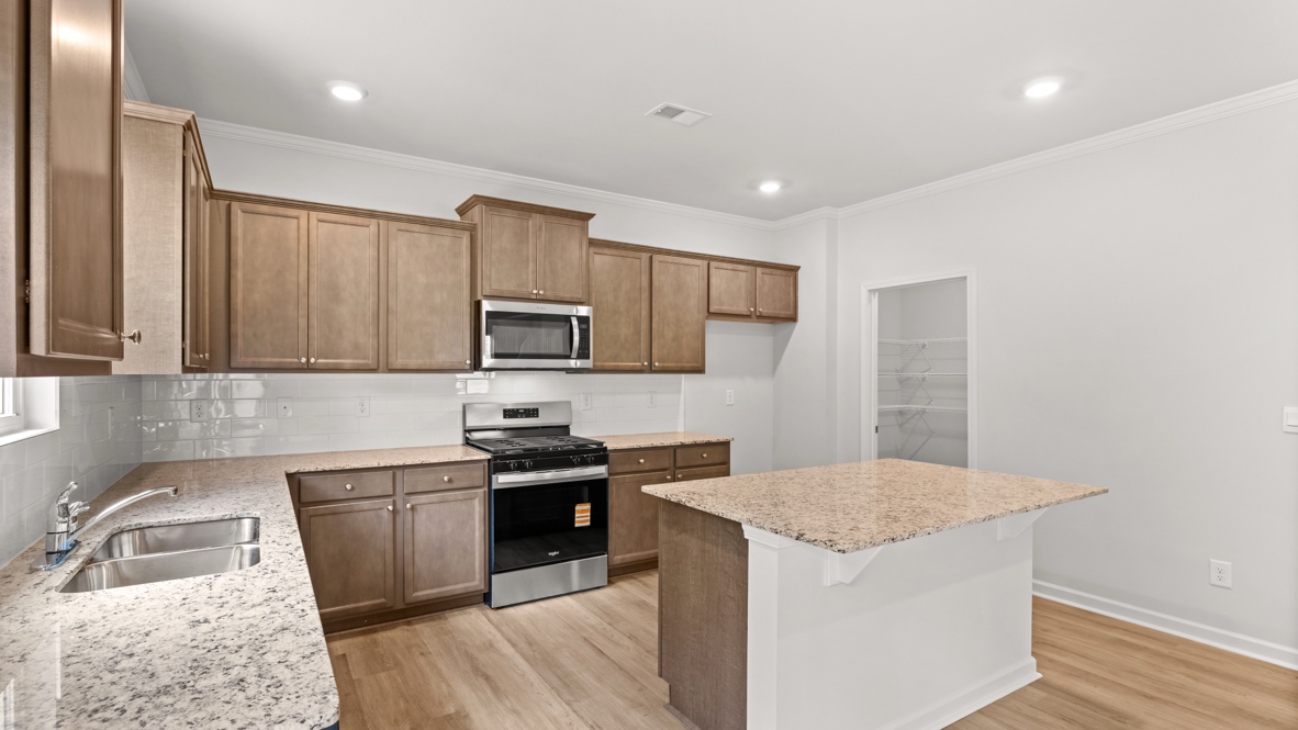 kitchen with brown cabinetry, large island and stainless steel appliances