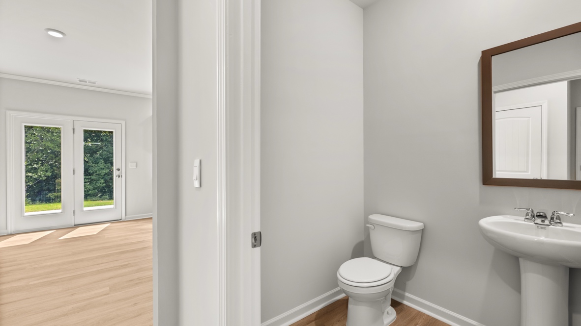 Powder bathroom with a pedestal sink and mirror